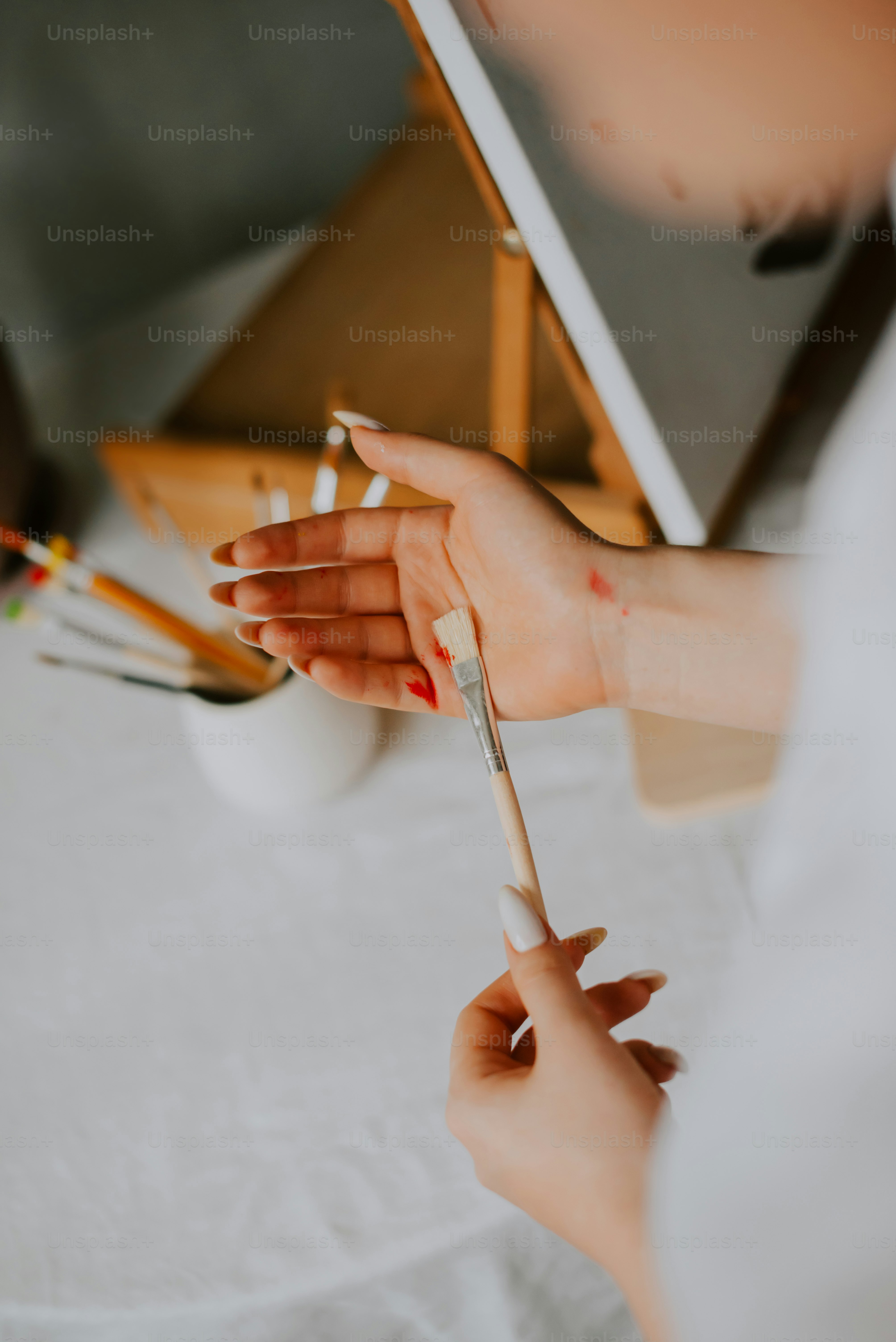 A woman is painting a picture on a easel photo – Painting Image on Unsplash