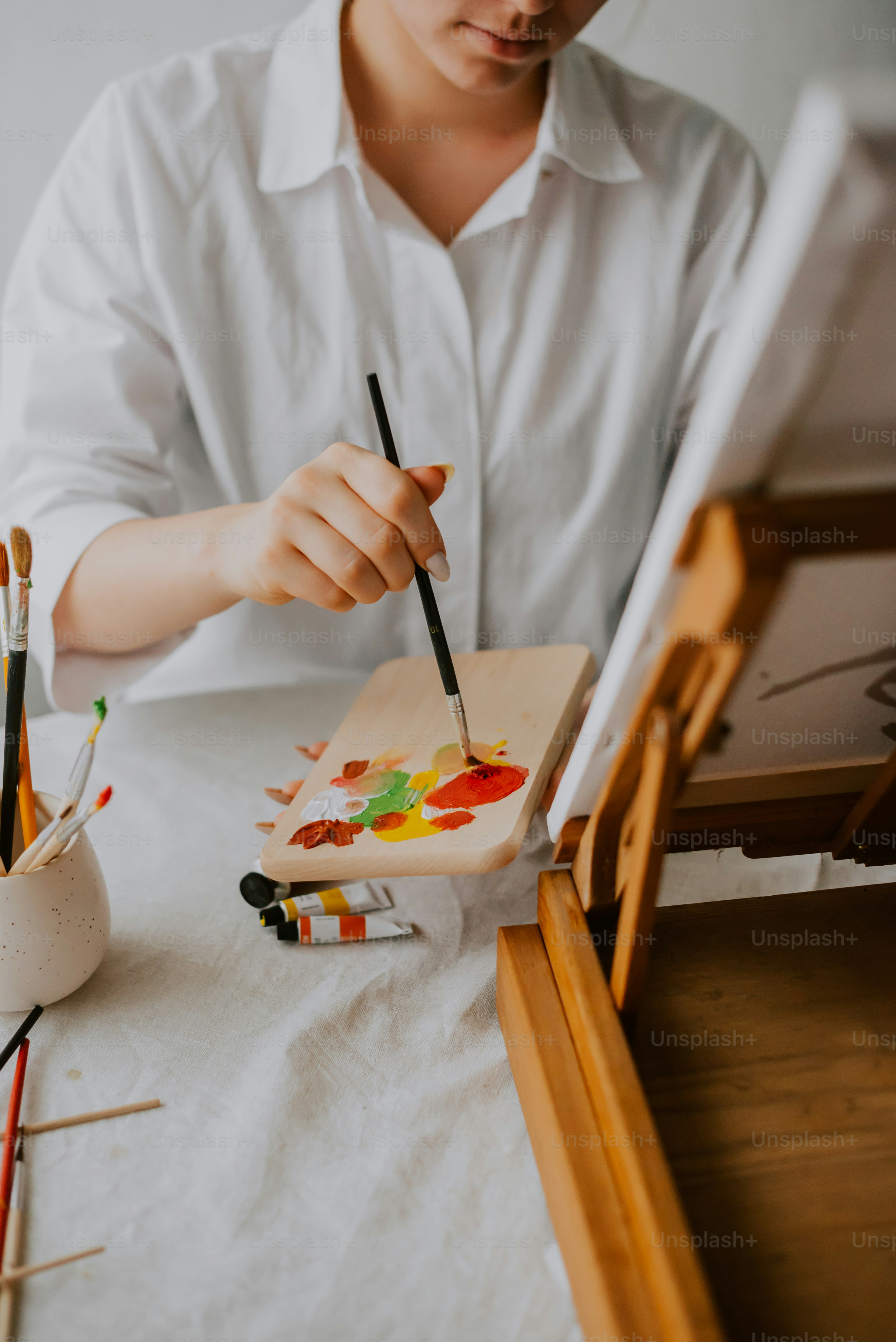 une personne assise à une table avec un pinceau