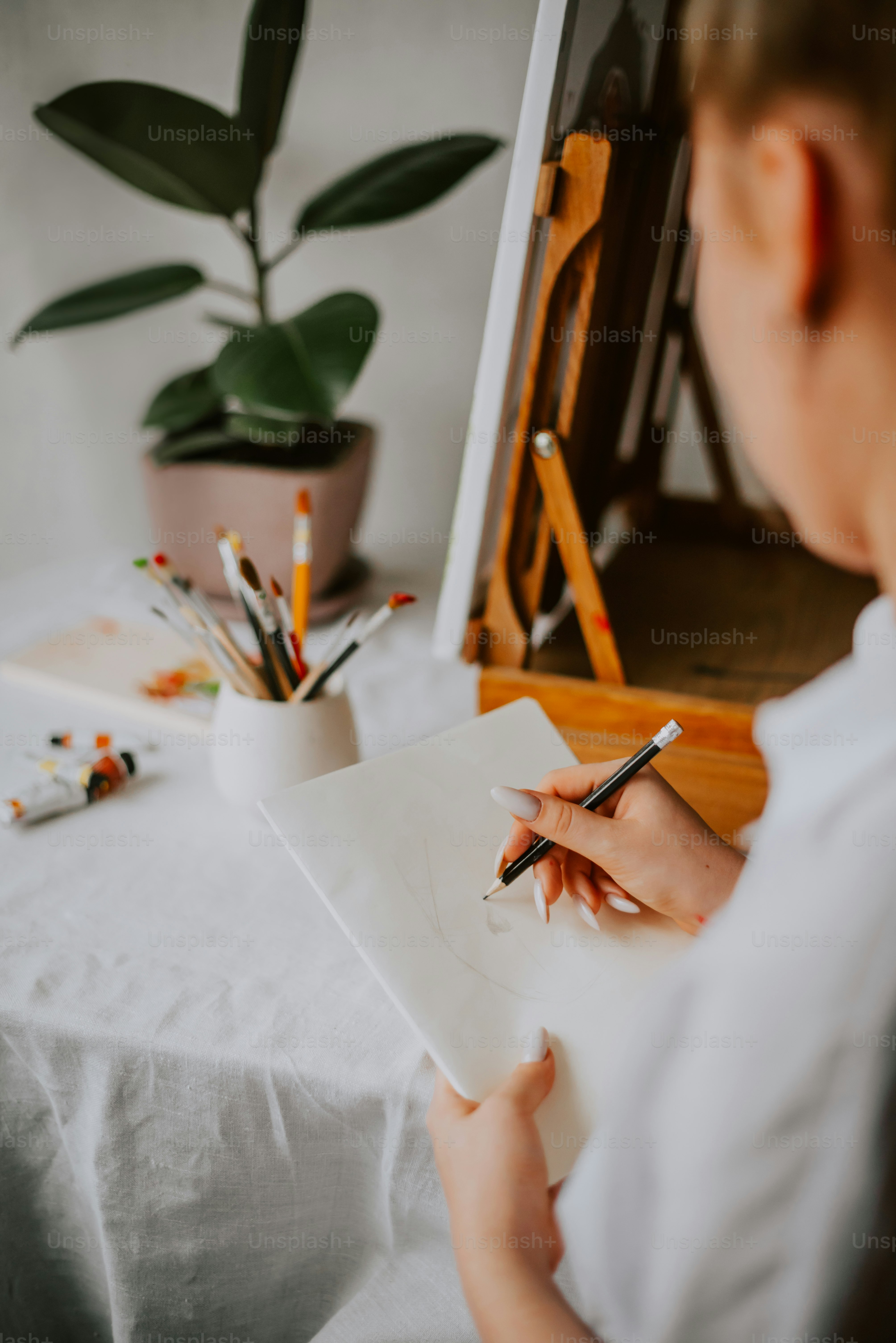 une femme assise à une table écrivant sur un morceau de papier