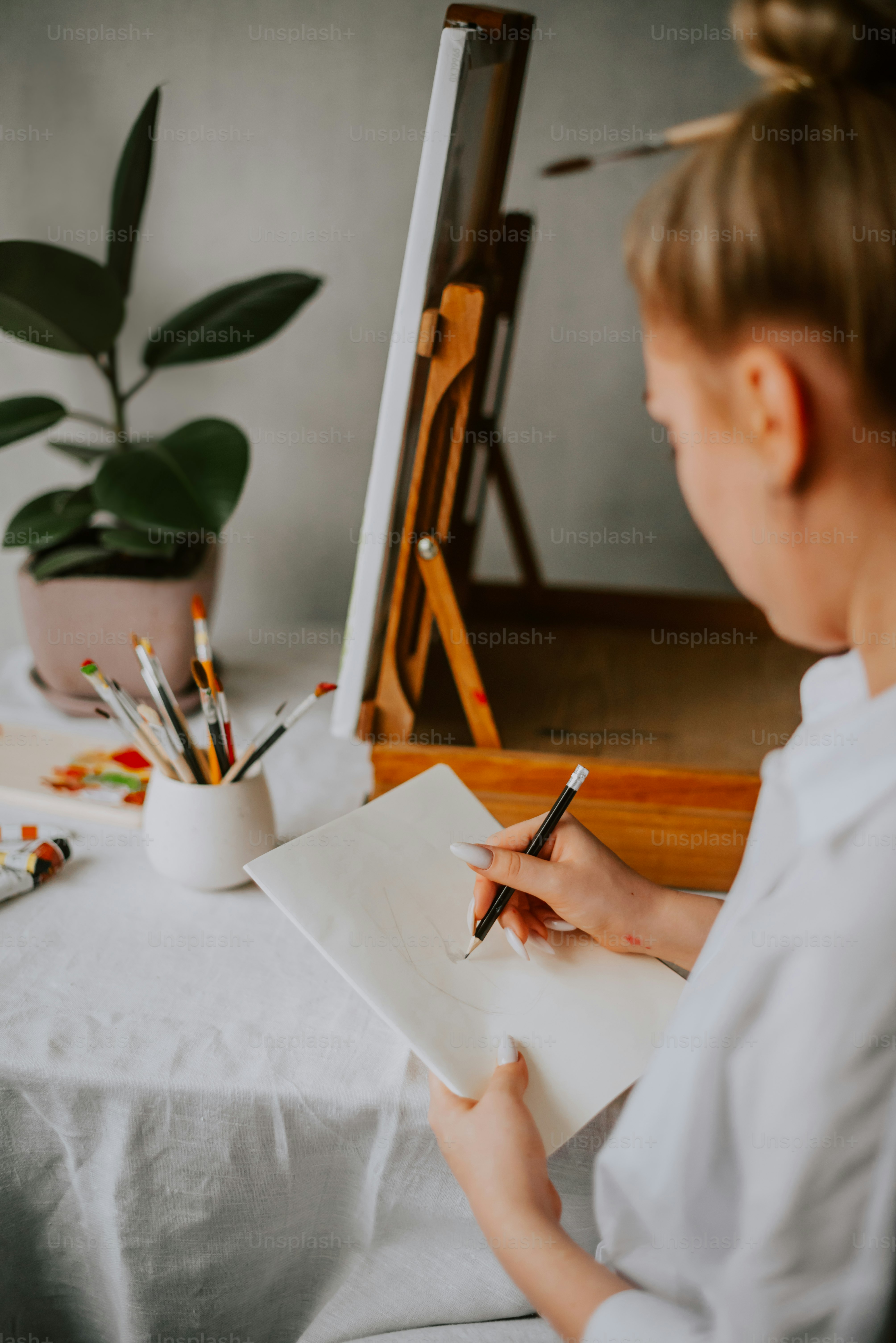 a woman sitting at a table writing on a piece of paper