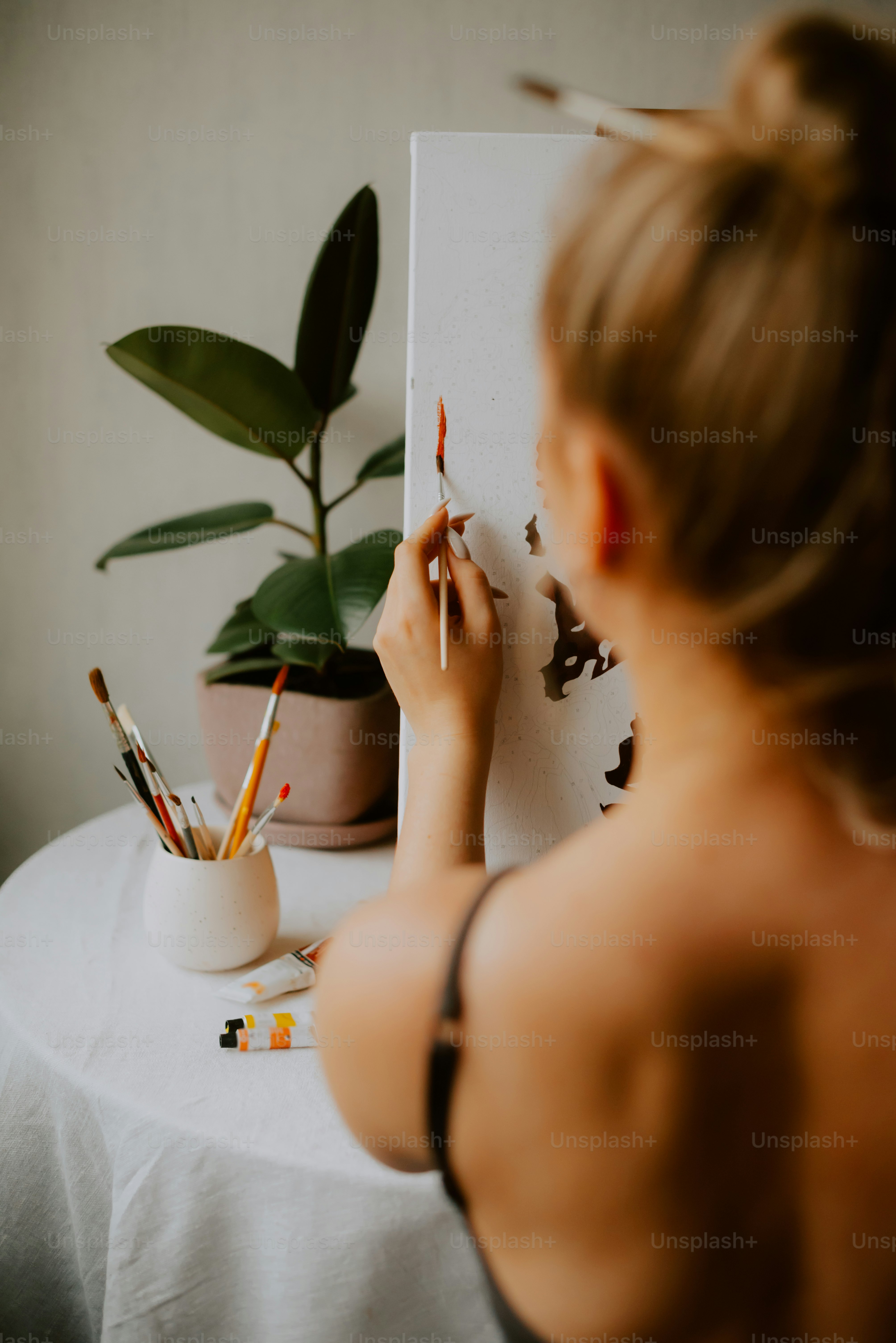 une femme assise à une table dessinant sur un morceau de papier