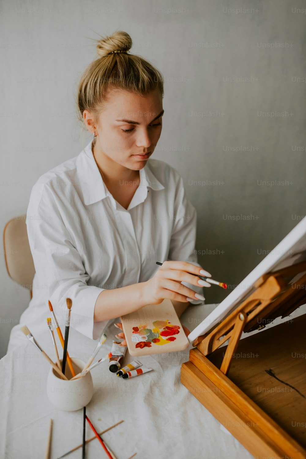 Una mujer sentada en una mesa con una pintura