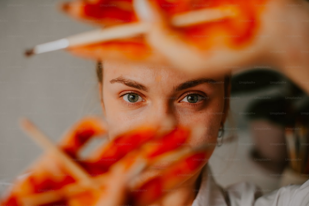 a woman holding up a bunch of pizza sticks