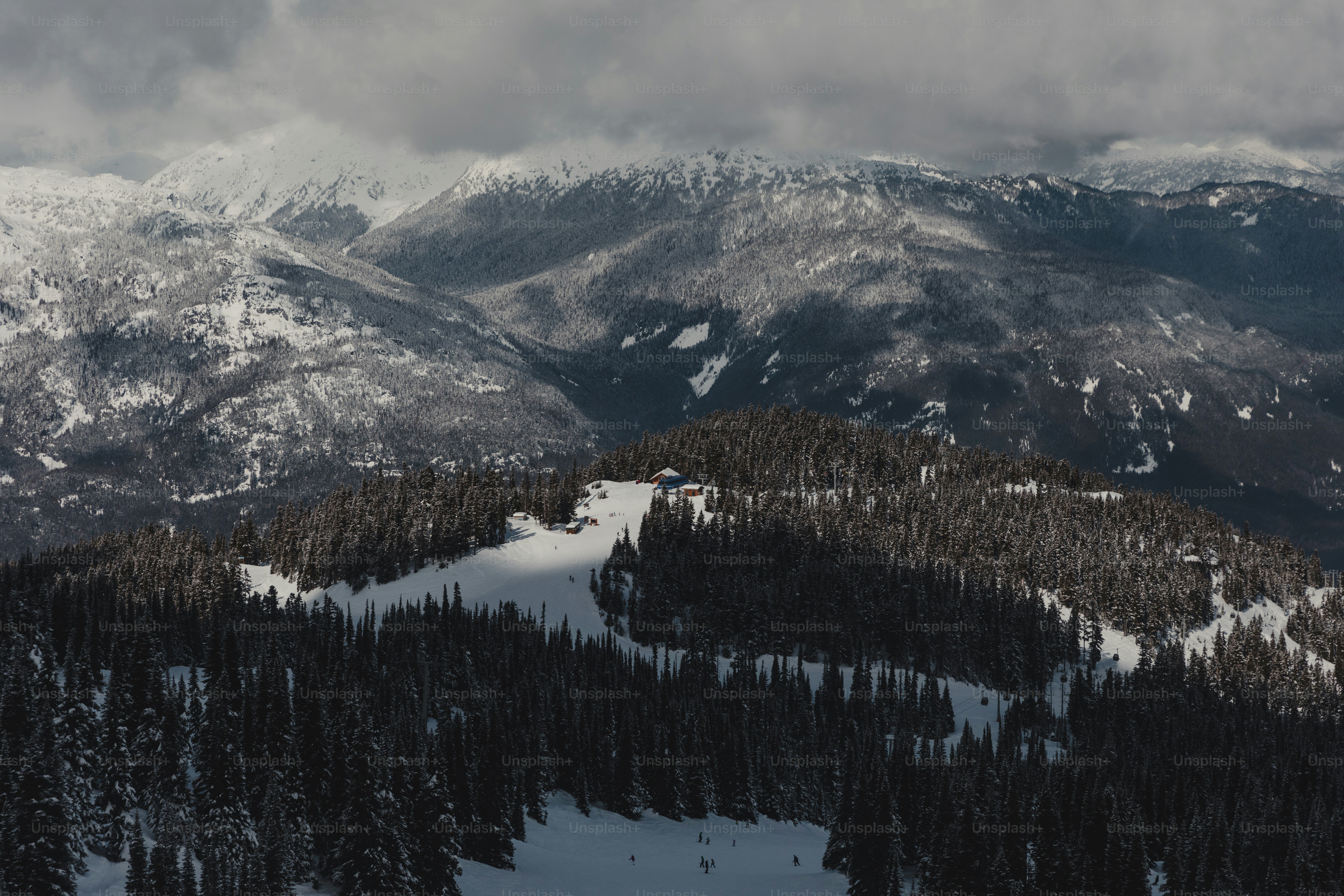 A snow covered mountain range with trees in the foreground photo – Snow ...