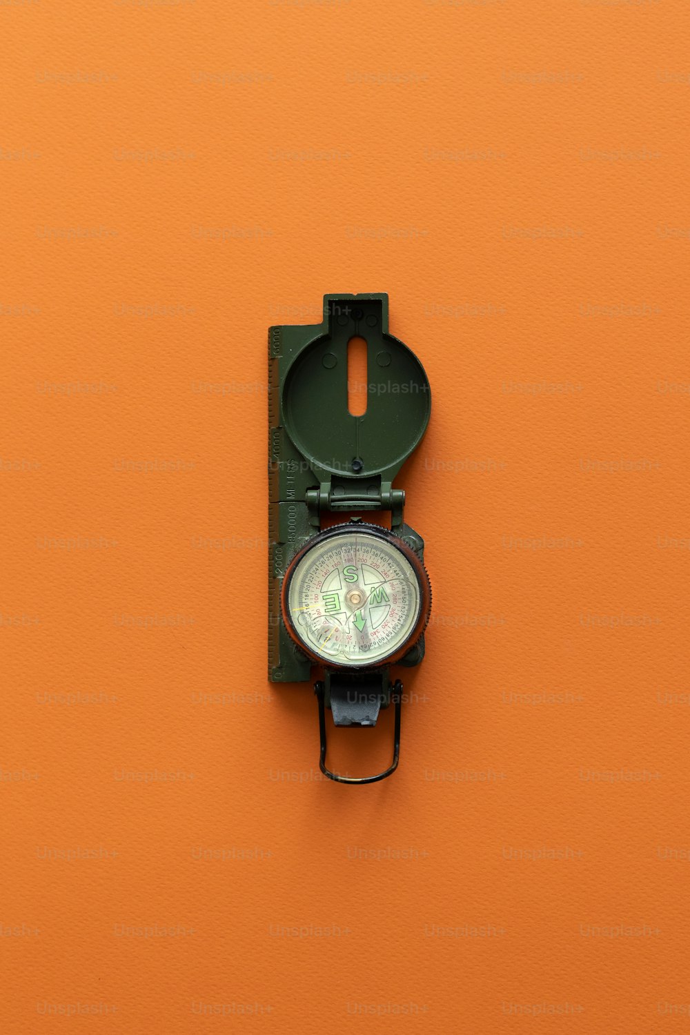 a compass mounted to a wall on an orange wall