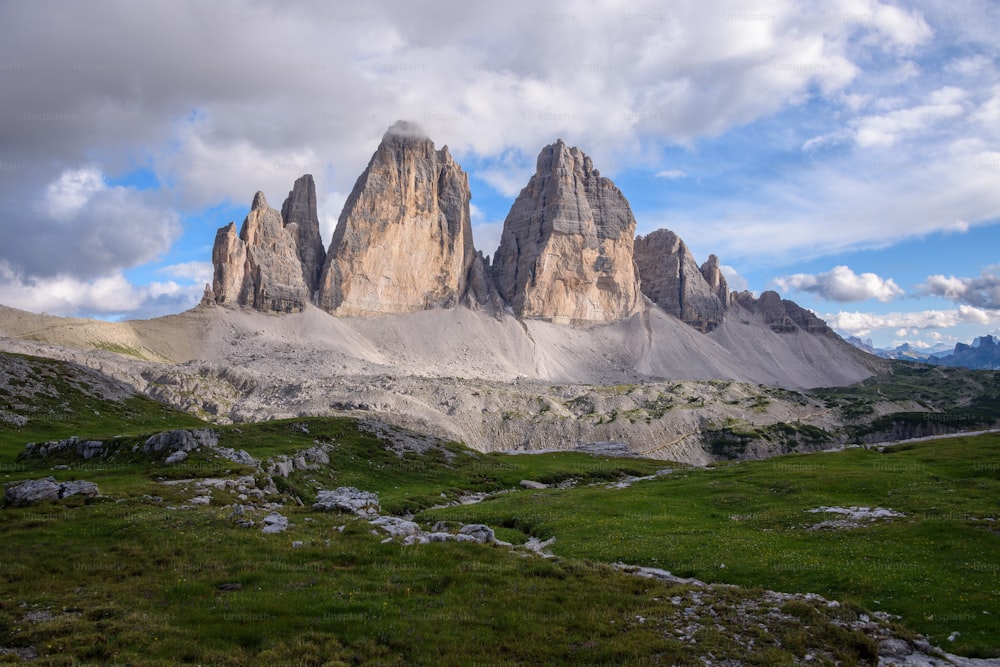 una cadena montañosa con un campo de hierba debajo