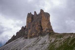 a very tall rock formation on a cloudy day