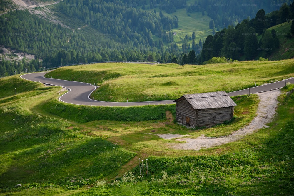 a small house on a winding road in the mountains