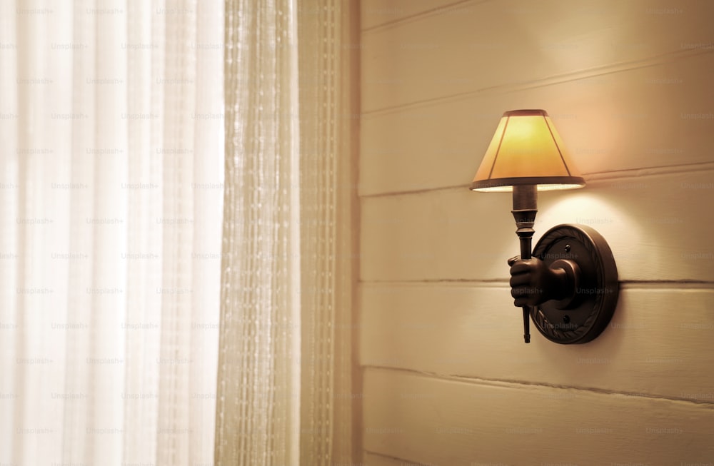 une lampe sur un mur à côté d’une fenêtre