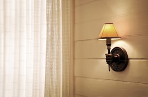 a lamp on a wall next to a window
