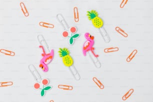 a group of paper clips with flamingos and pineapples on them