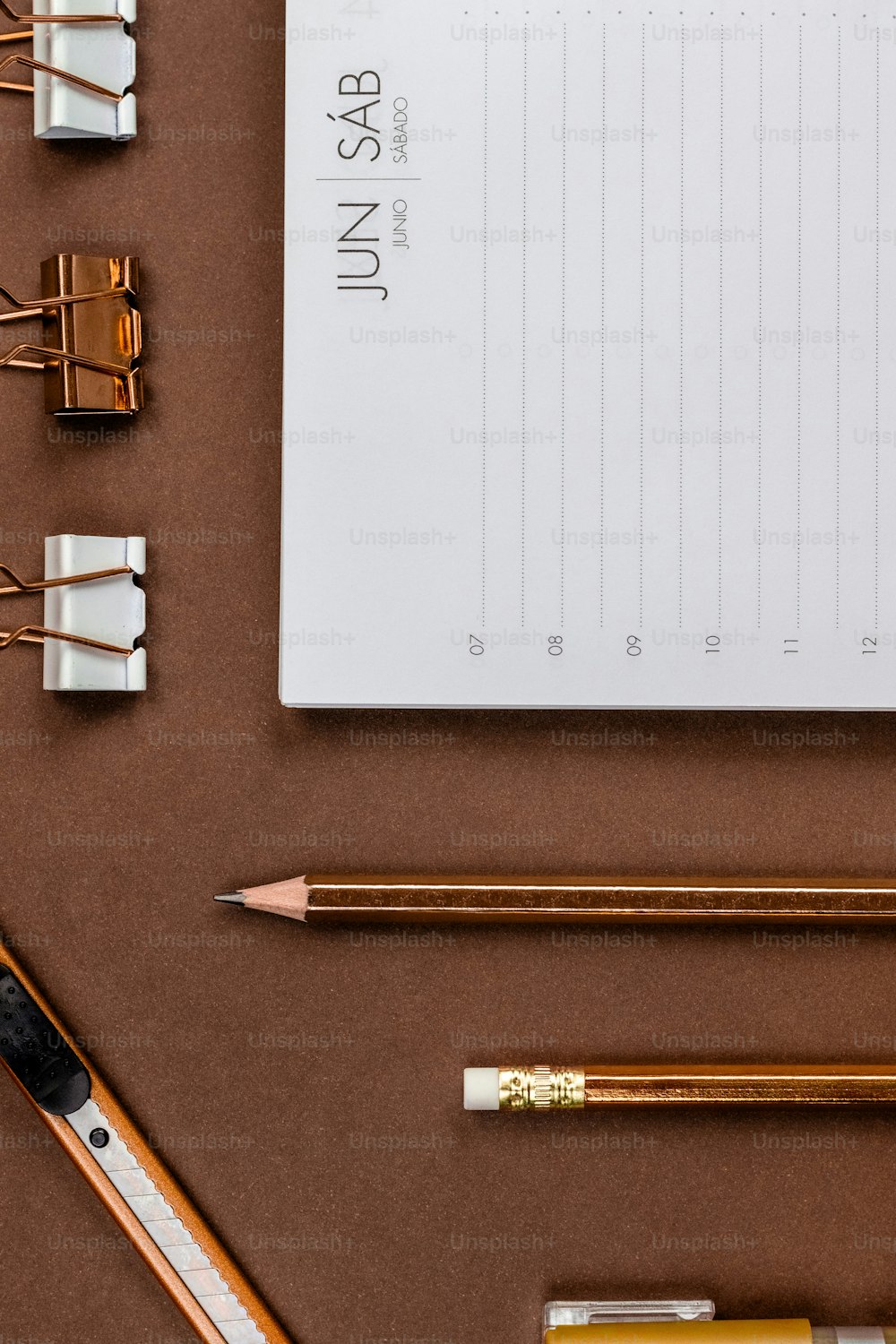 uma mesa com um bloco de notas, lápis e uma régua