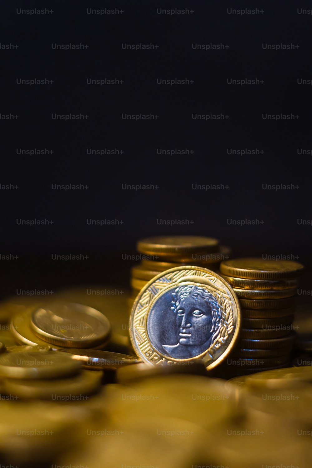 una pila di monete d'oro con una moneta sopra di essa