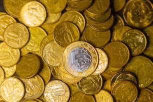 a pile of gold coins with a coin in the middle