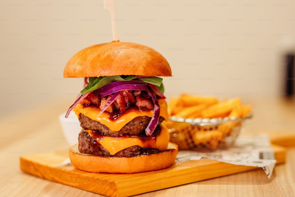 a cheeseburger on a cutting board with french fries