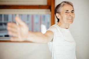 Uma mulher de camiseta branca está segurando o braço para fora