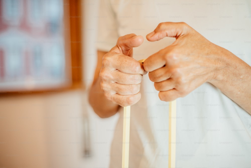 a person holding a pair of sticks in their hands