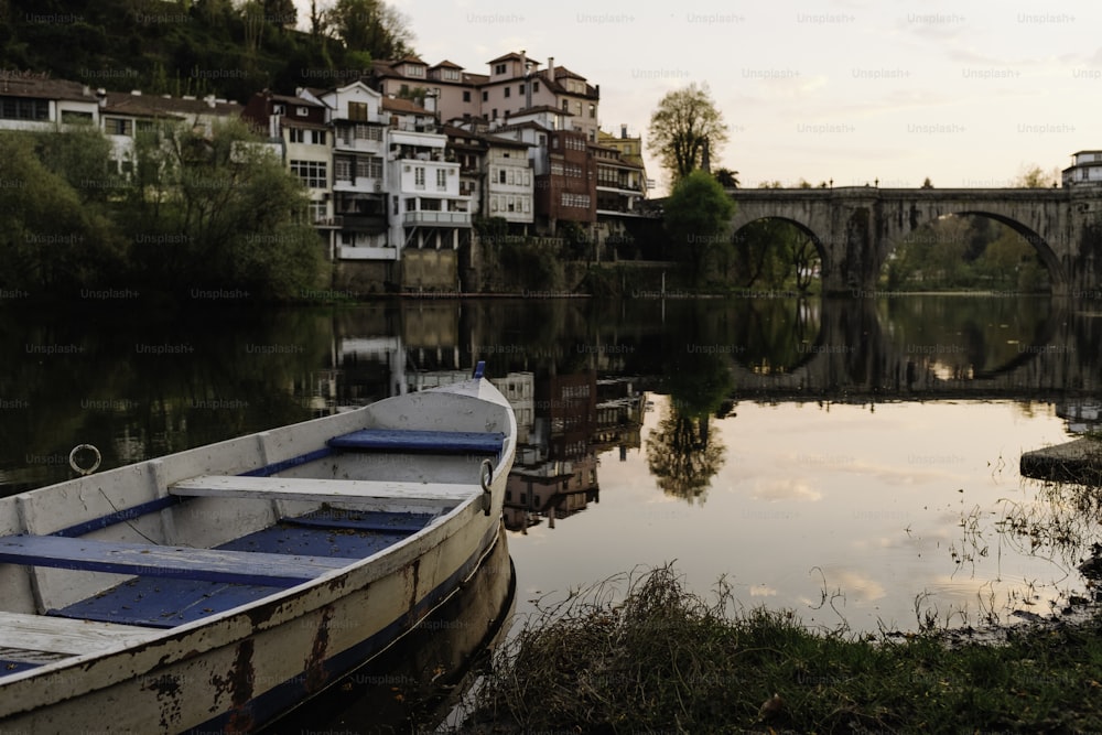 a small boat sitting on the shore of a river