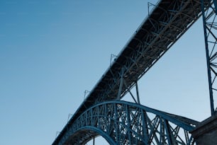 an airplane flying over a bridge on a clear day