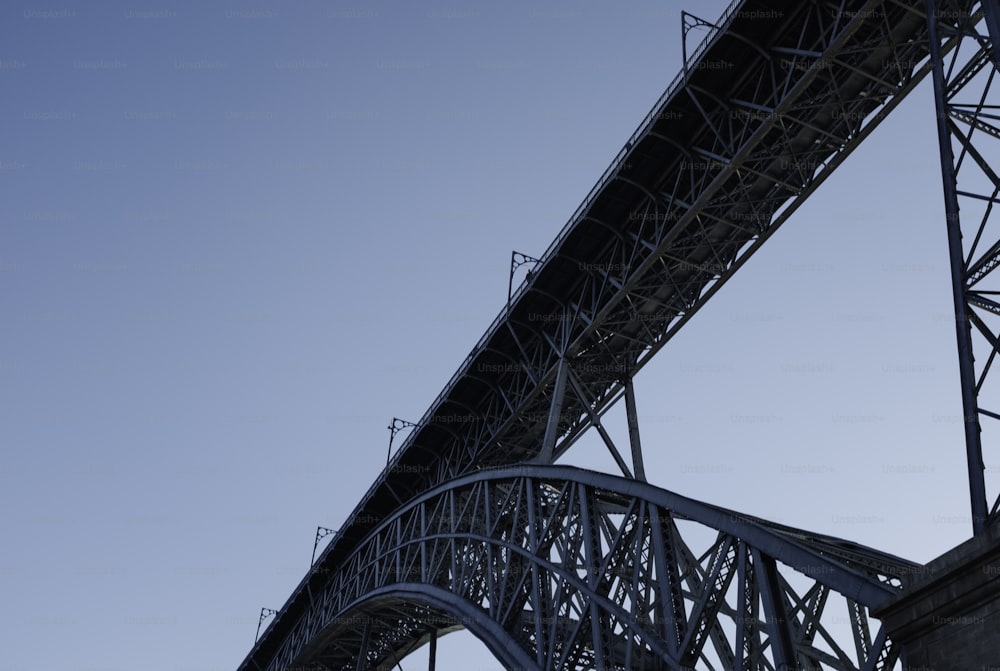 an airplane flying over a bridge on a clear day