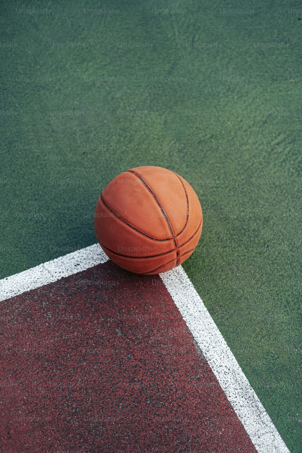a basketball sitting on top of a green court