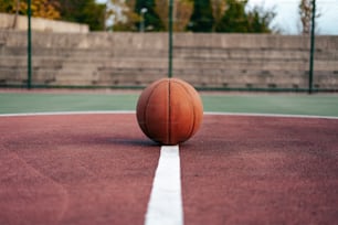 Una pelota de baloncesto sentada encima de una cancha de baloncesto