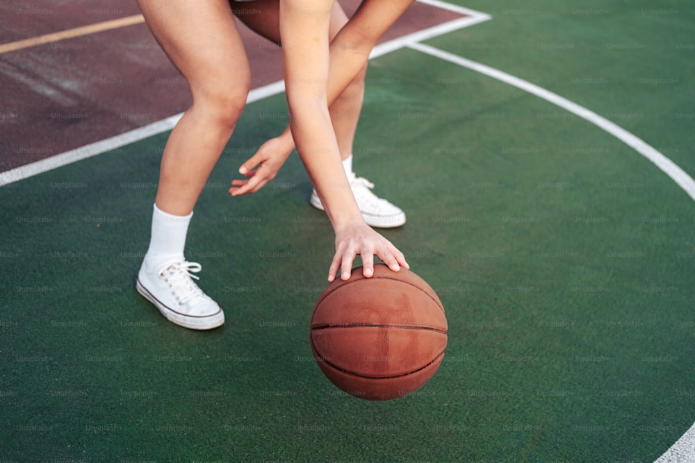uma mulher segurando uma bola de basquete em uma quadra de basquete