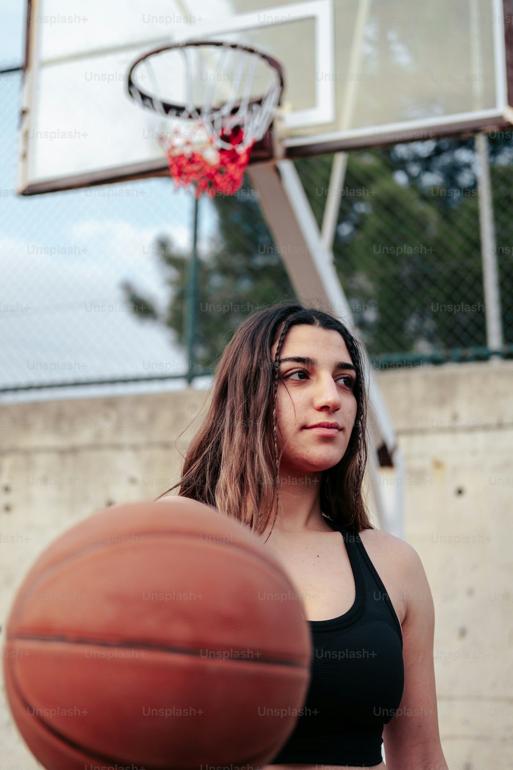 Une femme debout devant un panier de basket-ball