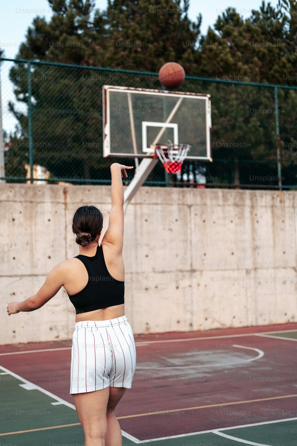 Una mujer está jugando baloncesto en una cancha