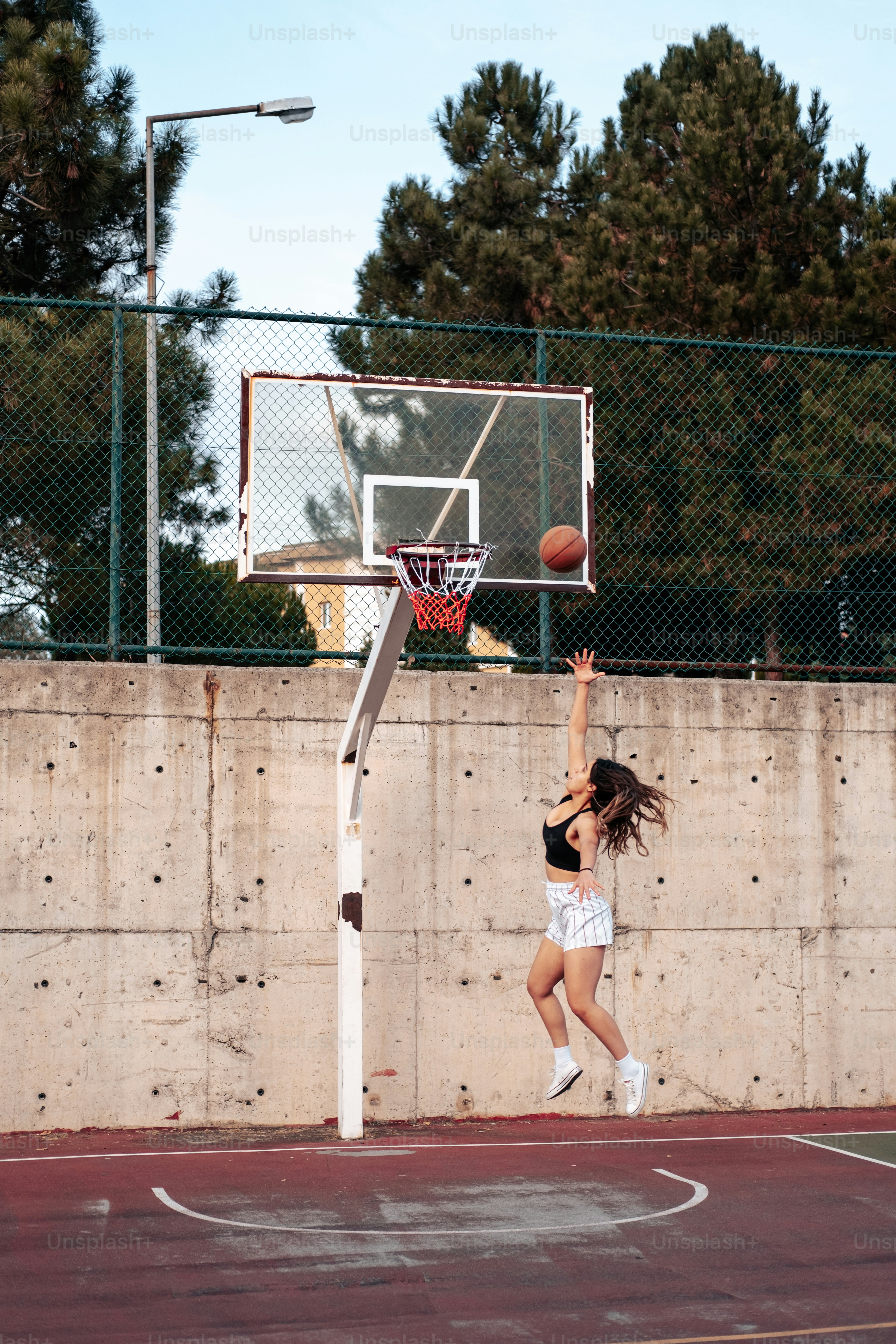 a woman jumping up to dunk a basketball