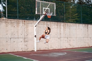 a person jumping up into the air to dunk a basketball