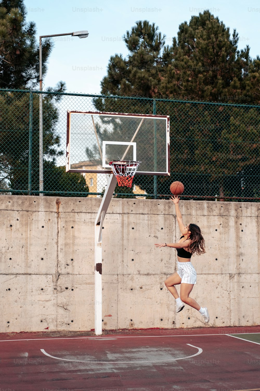 a woman jumping in the air to dunk a basketball