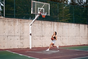 Uma mulher está jogando basquete em uma quadra