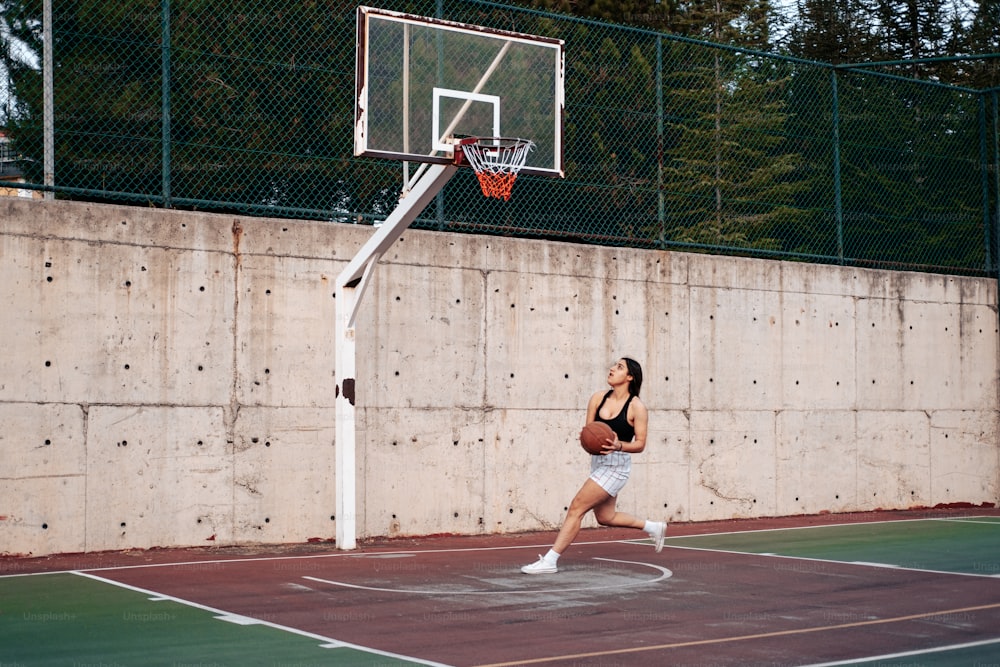 Una mujer está jugando baloncesto en una cancha