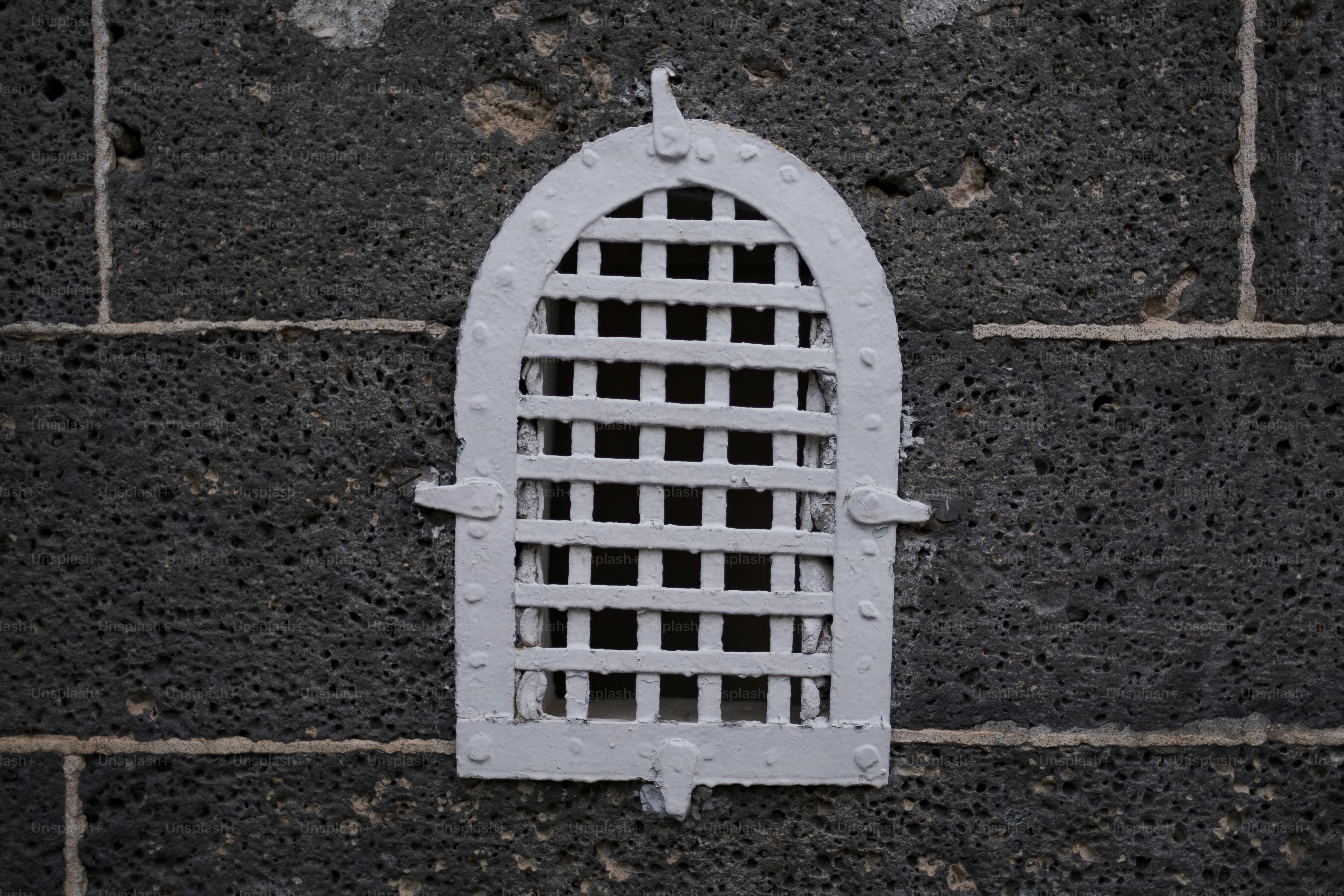 a close up of a white window on a brick wall