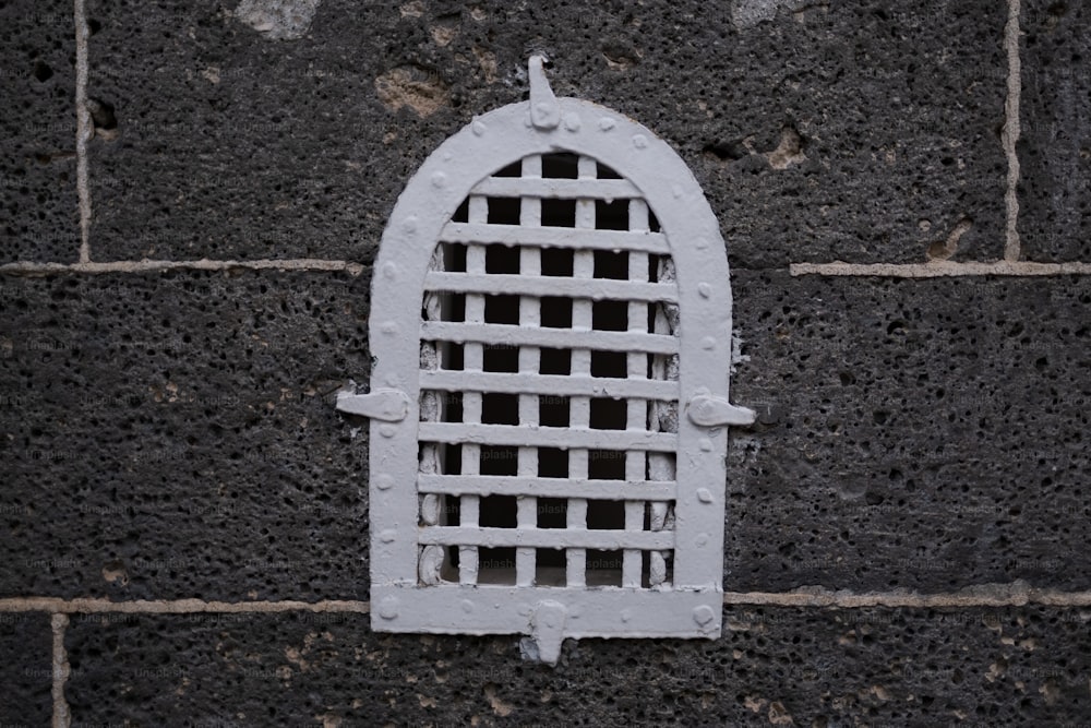 a close up of a white window on a brick wall