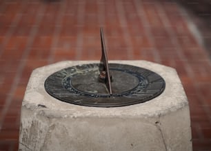 a sundial sitting on top of a cement block