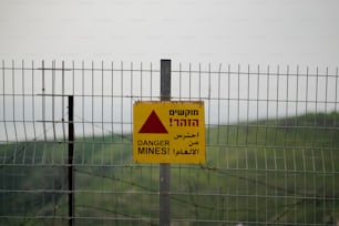 a warning sign is posted on a fence