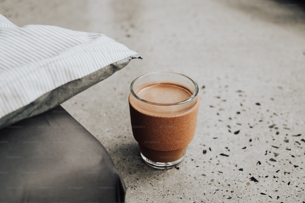 a glass of chocolate drink sitting on a table