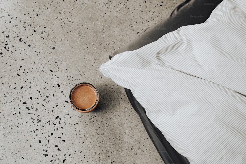 uma xícara de café sentada em cima de uma cama