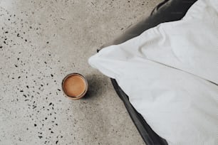 a cup of coffee sitting on top of a bed