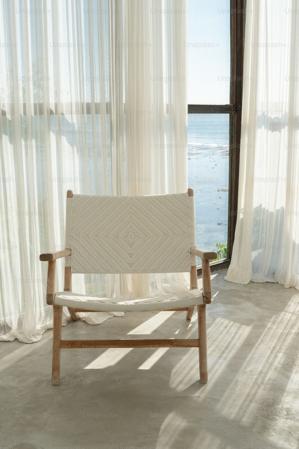 une chaise en bois assise devant une fenêtre