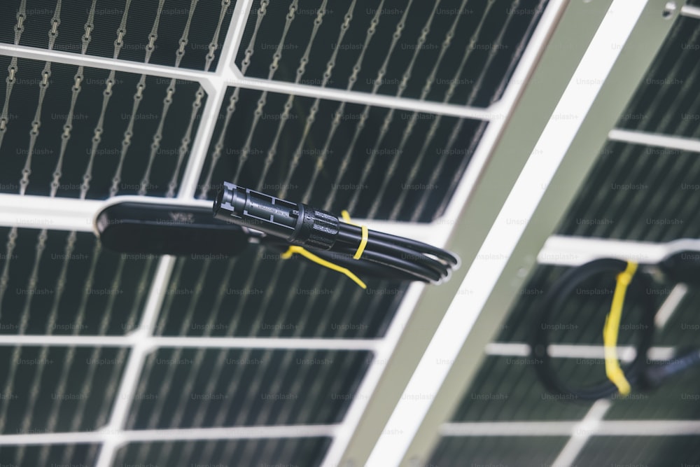 a close up of a black umbrella near a solar panel
