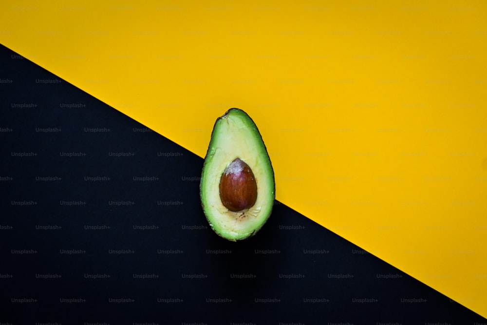 an avocado on a black and yellow background