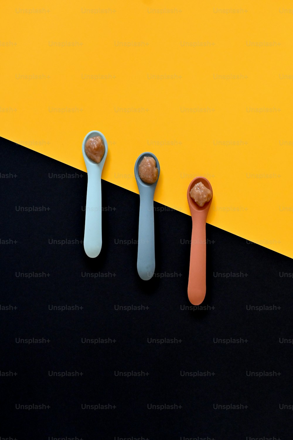 three spoons are lined up on a yellow and black background