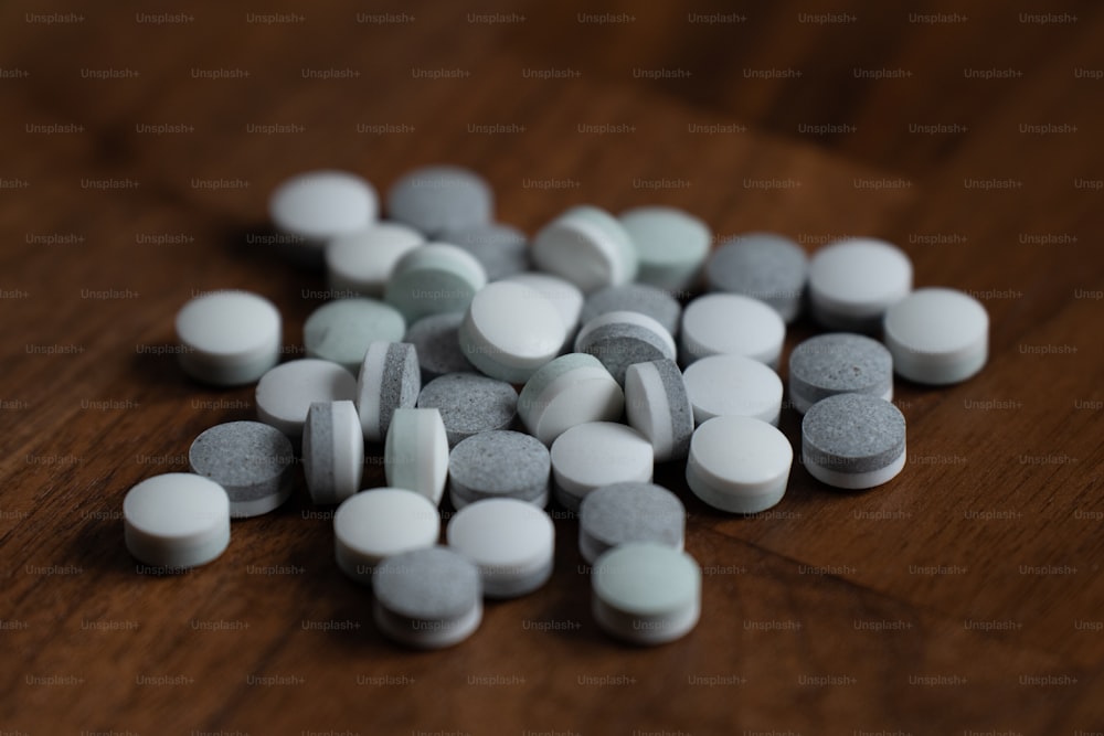 a pile of pills sitting on top of a wooden table