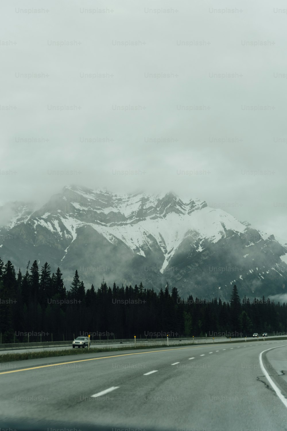 a car driving down a road with a mountain in the background