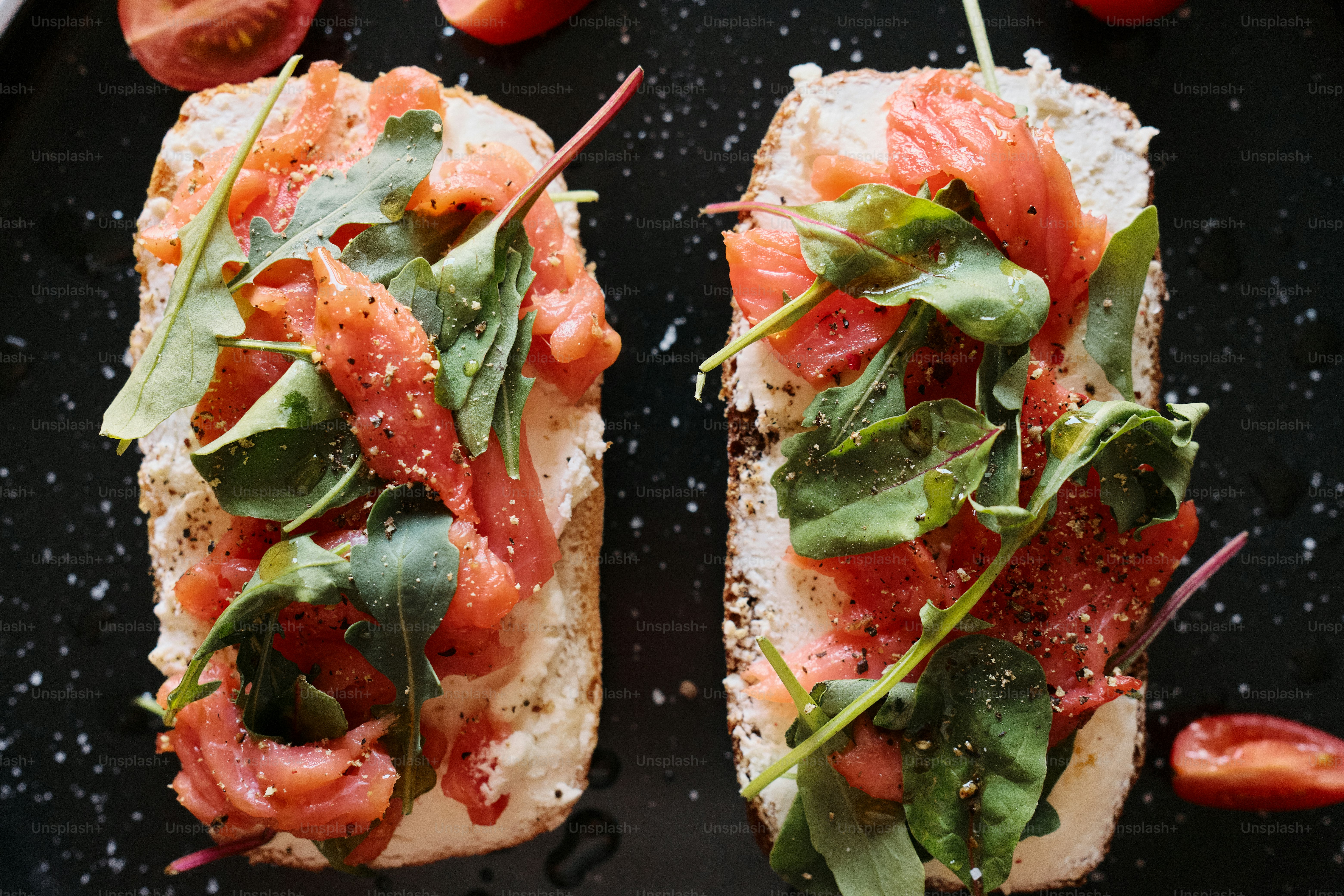 two pieces of bread with tomatoes and spinach on them