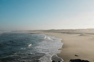 vista para uma praia com ondas vindas do oceano