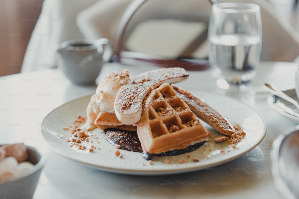 a white plate topped with waffles covered in powdered sugar